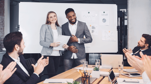 man-and-woman-being-clapped-by-team-in-office